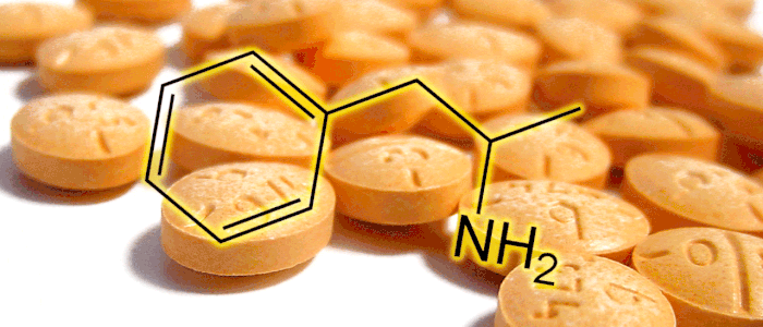 A pulsating amphetamine molecule in front of a background of orange pills